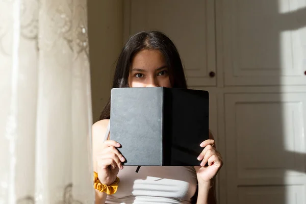 Jovem Mulher Cobrindo Seu Rosto Com Livro Preto Mulher Hispânica — Fotografia de Stock