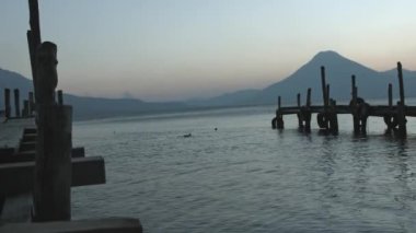 atitlan göl rıhtımında gün batımı, volkan arka planıyla, gün batımında kırsal iskelede güzel bir göl manzarası.