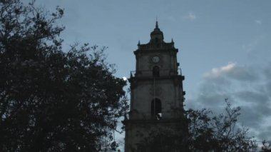 Gökyüzü ile antik mimaride saat kulesi, Central Park 'ta sömürge mimari belediyesi ile günbatımı ve günbatımında arka planda ay.