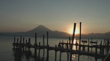 atitlan göl rıhtımında gün batımı, volkan arka planıyla, gün batımında kırsal iskelede güzel bir göl manzarası.