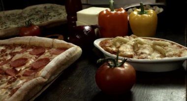 Kare İtalyan biberli ve peynirli pizza, ev yapımı yemek tarifi, malzemeli pizza mutfakta taze malzemelerle çevrili, ahşap bir masanın üzerinde.