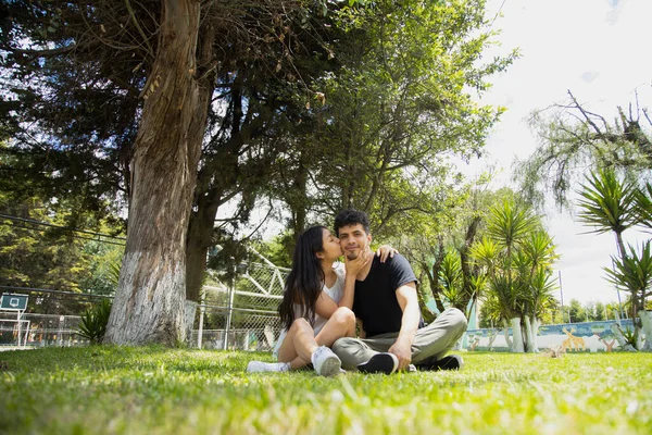 Молодая Латиноамериканская Пара Влюблена Сидя Траве Обнимаясь Веселясь Пара Прогуливается — стоковое фото