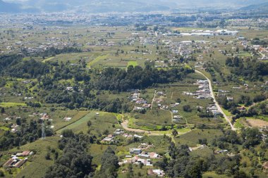 Quetzaltenango Guatemala 'daki kırsal bir banliyöde ağaçlar ve ekinlerle çevrili kırsal köyler yukarıdan görülebiliyor.