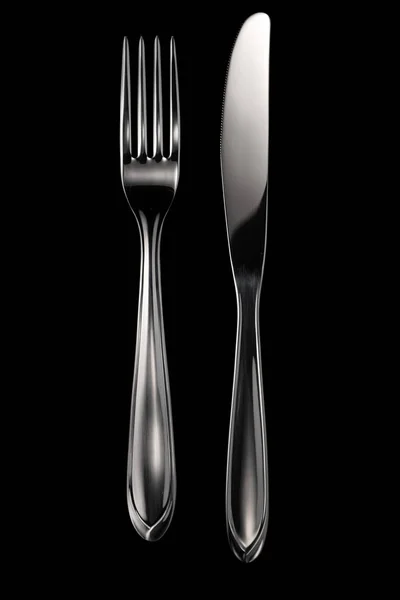 黒い背景に孤立したフォークとナイフ — ストック写真