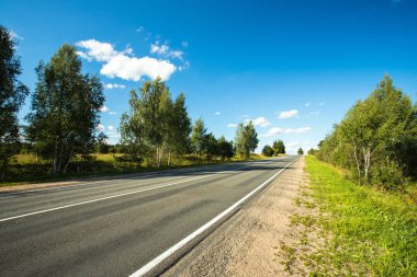 Yaz aylarında güneşli günde mavi gökyüzü altında boş asfalt yol ile güzel manzara.
