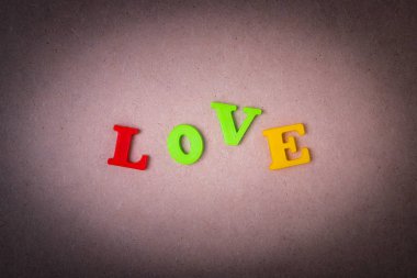 Kahverengi doku Vignette üstten görünüm ile ahşap tahta arka plan üzerinde renkli yazıt aşk.