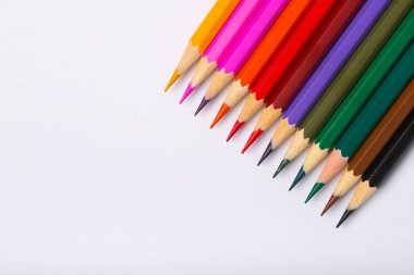 Boşaltmak yakından ile Beyaz Kağıt arka plan üzerinde renkli renkli kalemler.