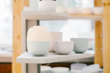 Yumuşak arkaplanda çok renkli seramik minimalist vazo ve fincanlar.