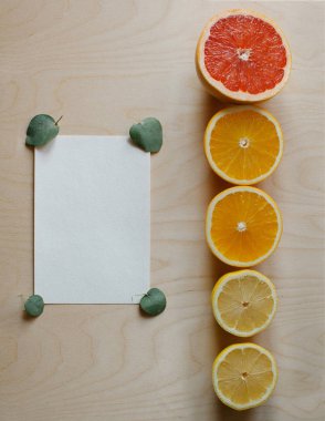 Okaliptüs yaprakları ve narenciye ile doğal ahşap masa üzerinde fotokopi alanı boş arkaplan. Kopyalama alanı olan üst görünüm, düz görünüm, en düşük biçim.