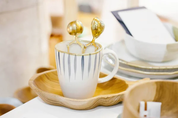 Set of cup of tea  with vintage tea strainer on wooden stand.