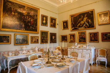 Şatonun içi. Oturma odası, masa ve sandalyeler. Porselen tabaklar ve şamdanlar masanın üzerinde duruyor. Klasik tarzda bir şato. Duchcov Şatosu, Çek Cumhuriyeti, 19 Eylül 2020