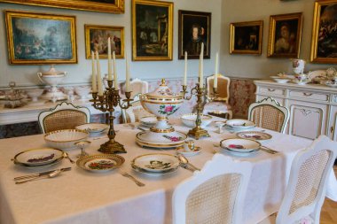 Şatonun içi. Oturma odası, masa ve sandalyeler. Porselen tabaklar ve şamdanlar masanın üzerinde duruyor. Klasik tarzda bir şato. Duchcov Şatosu, Çek Cumhuriyeti, 19 Eylül 2020