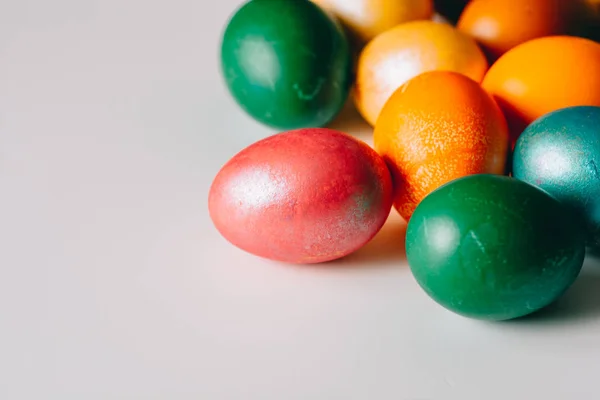 Small multi-colored Easter eggs on the kulich, festively decorated with colorful painted eggs paint, background