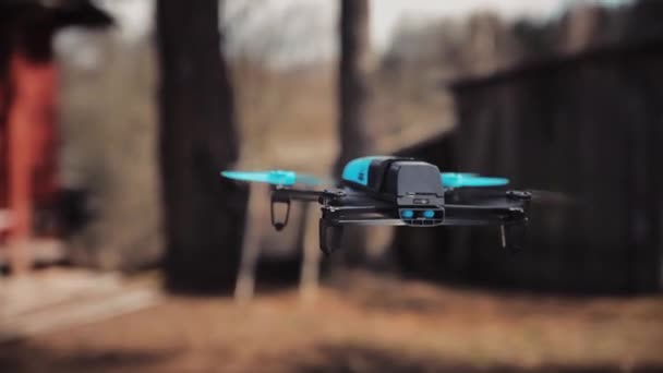 O drone azul pairou no ar contra os outbuildings — Vídeo de Stock