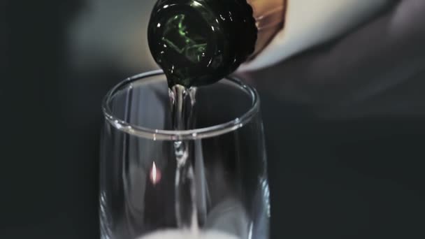 Champán vierte desde el cuello de la botella en el vidrio brilla en la superficie burbujas suben — Vídeo de stock