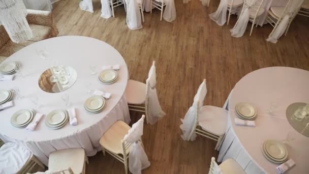 Сервированный стол с белой тканью, на которой тарелки и салфетки — стоковое видео