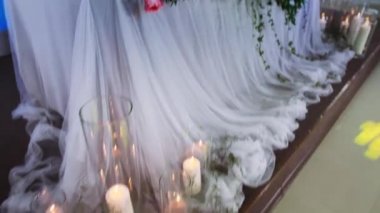 bir çiçek düzenleme ve bir kemer ile dekore edilmiş yeni evliler presidyum disko ışıkları çalışmak