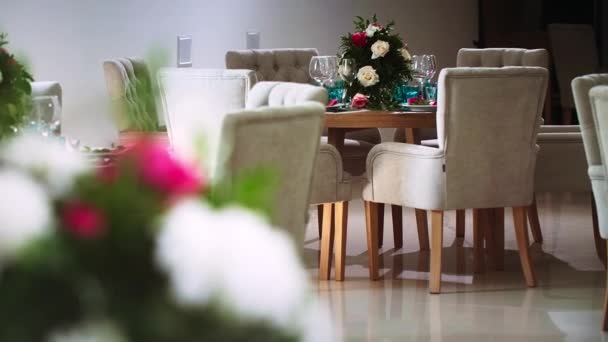 Round wooden table around which there are chairs and in the interior of the banquet hall — Stock Video