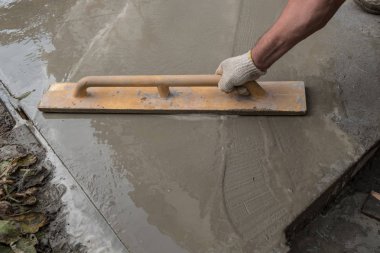 Manuel modda bir konut kırsal evin etrafında bir beton kaldırım inşaatı. El ile pişmiş harç beton karıştırıcı. Özel bir araç ile kaldırım yüzey tesviye