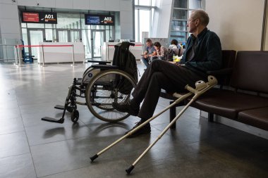 St. Petersburg, Rusya Federasyonu - 8 Ekim 2018: çetele uçuş programı ile görünüyor uçağa binmeden önce yaşlı kel bir kişi gidiş salonunda devre dışı.