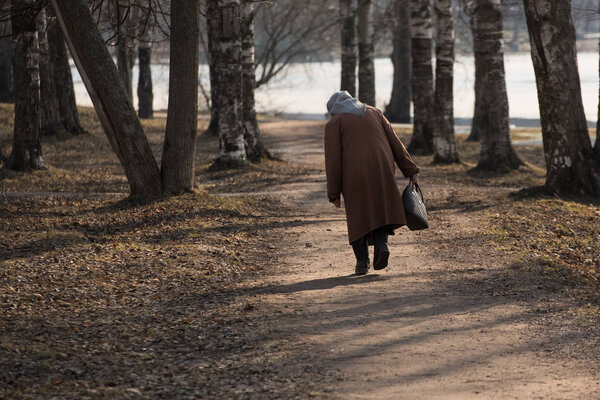 Неузнаваемая старуха идет по осеннему переулку. Как символ старости и жизни. В руках ее сумки. На шарфе. Нестабильная искривлённая походка
.