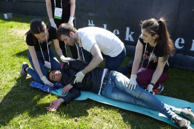 St. Petersburg, Rusya Federasyonu - 12 Mayıs 2018: yarışma / egzersizleri ilk yardım öncesi hastane aşamada. Üç genç insanlar kaza bilinçsiz adam yardımcı oluyor.