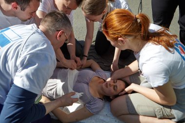 St. Petersburg, Rusya Federasyonu - 12 Mayıs 2018: yarışma / egzersizleri ilk yardım öncesi hastane aşamada. Tıbbi ekip yerde yatan baygın kıza yardım sağlar.
