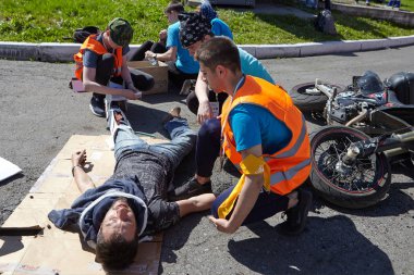 St. Petersburg, Rusya Federasyonu - 12 Mayıs 2018: yarışma / egzersizleri ilk yardım öncesi hastane aşamada. Motosikletçi üç genç kişilere yol işçileri rolü yardımcı.
