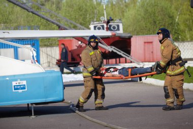 St. Petersburg, Rusya Federasyonu - 12 Mayıs 2018: yarışma / egzersizleri ilk yardım öncesi hastane aşamada. İtfaiyeciler uçakta yangın sırasında kurban sedye üzerinde yürütmek.