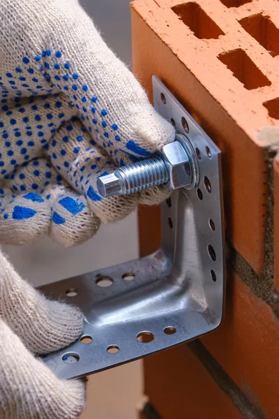 Stage of installation of a chemical anchor in a red building brick with cellular voids. Demonstration of the correctness of the actions of the builder. Close-up.