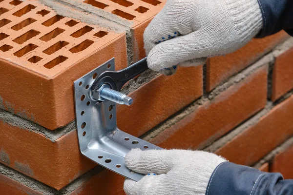 Bir kırmızı bina tuğla hücresel boşlukları ile kimyasal bir çapa yükleme aşaması. Builder eylemlerinin doğruluğunu gösteri. Yakın çekim.