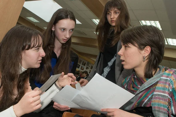 Quatro meninas discutem o tema das aulas na escola científica e na universidade. — Fotografia de Stock