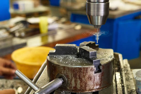 O processo de fabricação de uma pequena peça de metal em uma perfuração ma — Fotografia de Stock