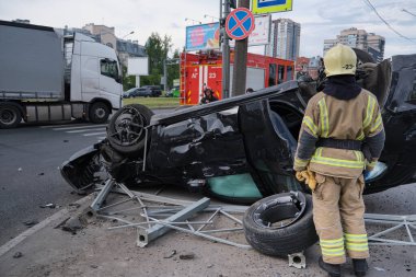 Saint Petersburg, Rusya - 21 Temmuz 2020: Çeroki SUV cipi şehirde meydana gelen şiddetli bir trafik kazasından sonra ters çevrildi. İtfaiyeciler gaz tankı patlama tehdidini ortadan kaldırdı