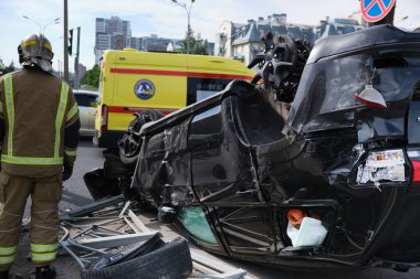 Saint Petersburg, Rusya - 21 Temmuz 2020: Çeroki SUV cipi şehirde meydana gelen şiddetli bir trafik kazasından sonra ters çevrildi. İtfaiyeciler gaz tankı patlama tehdidini ortadan kaldırdı