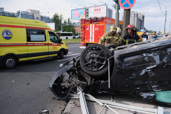 Saint Petersburg, Russia - July 21, 2020: Cherokee SUV jeep inverted after a severe road collision in the city. Firefighters eliminate gas tank explosion threat
