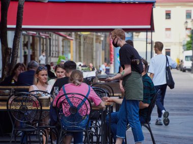 St. Petersburg, Rusya - 29 Haziran 2020: Covid-19 salgınından sonra şehir merkezinde yaz kafeleri ve restoranlar açıldı. Terastaki insanlar, veranda, yaz günü, dinlenme, iyi bir ruh hali.     