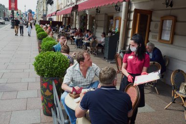 St. Petersburg, Rusya - 29 Haziran 2020: Covid-19 salgınından sonra şehir merkezinde yaz kafeleri ve restoranlar açıldı. Terastaki insanlar, veranda, yaz günü, dinlenme, iyi bir ruh hali.     