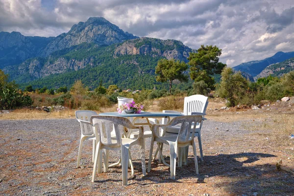 Mesa Plástico Branco Com Cadeiras Contra Pano Fundo Das Montanhas — Fotografia de Stock