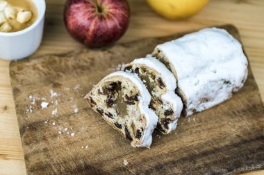 Noel kek üzümlü yakın çekim yukarıdan eski ahşap kesme tahtası ile tüm elma ve hatmi ile kahve tabloda görüntülenen beyaz sır dilimlenmiş. Kopya alanı