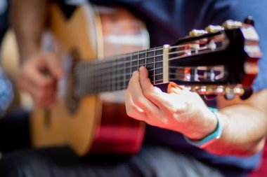 Adam akustik gitar çalıyor.