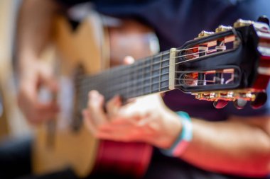 Adam akustik gitar çalıyor.