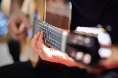 Adam akustik gitar çalıyor.