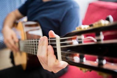 Adam akustik gitar çalıyor.