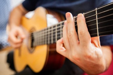 Adam akustik gitar çalıyor.