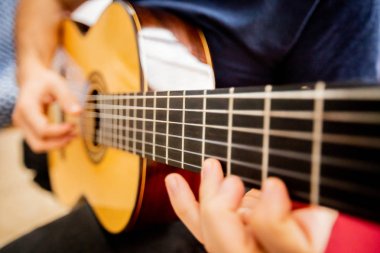 Adam akustik gitar çalıyor.