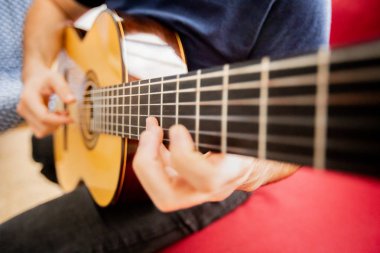 Adam akustik gitar çalıyor.