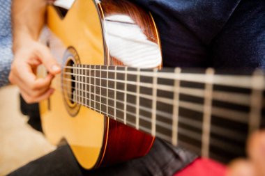 Adam akustik gitar çalıyor.