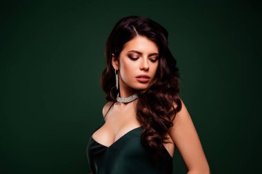 Zarif kıyafetli güzel esmer kadın yeşil arka planda şık makyajlı, ışıl ışıl bir güzellik.