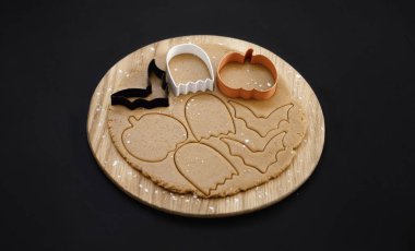 Karanlık bir arka planda Cadılar Bayramı zencefilli kurabiyeleri. Cadılar Bayramı partisi için ev yapımı kurabiyeler. Balkabağı, hayalet, yarasa, mumya, iskelet. Cadılar Bayramı arkaplanı ve mesaj için boşluk. Üst Manzara. Model.